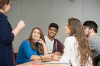 Students with a teacher in discussion at a table