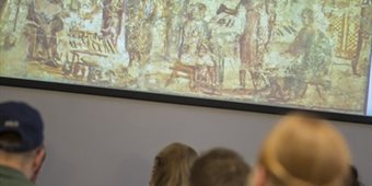 Students look at a slide with artwork on