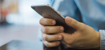 A closeup of a person holding an iPhone in their hands.