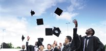 A group of students at graduation throw their caps in the air.