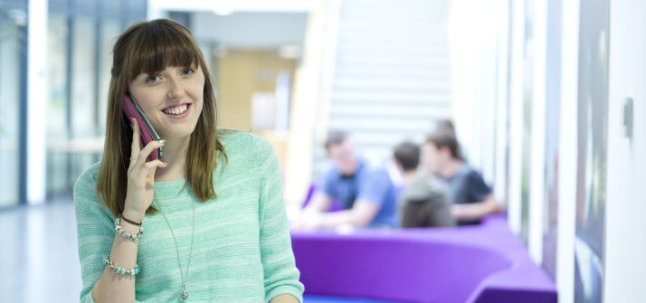 Female undergraduate on the phone in the School of Mathematical Sciences building