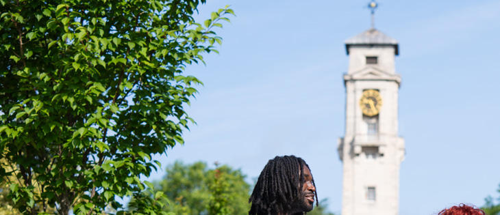Students on University Park campus with Trent Building clock tower in the background.