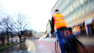 Cyclist wearing bright, reflective clothing