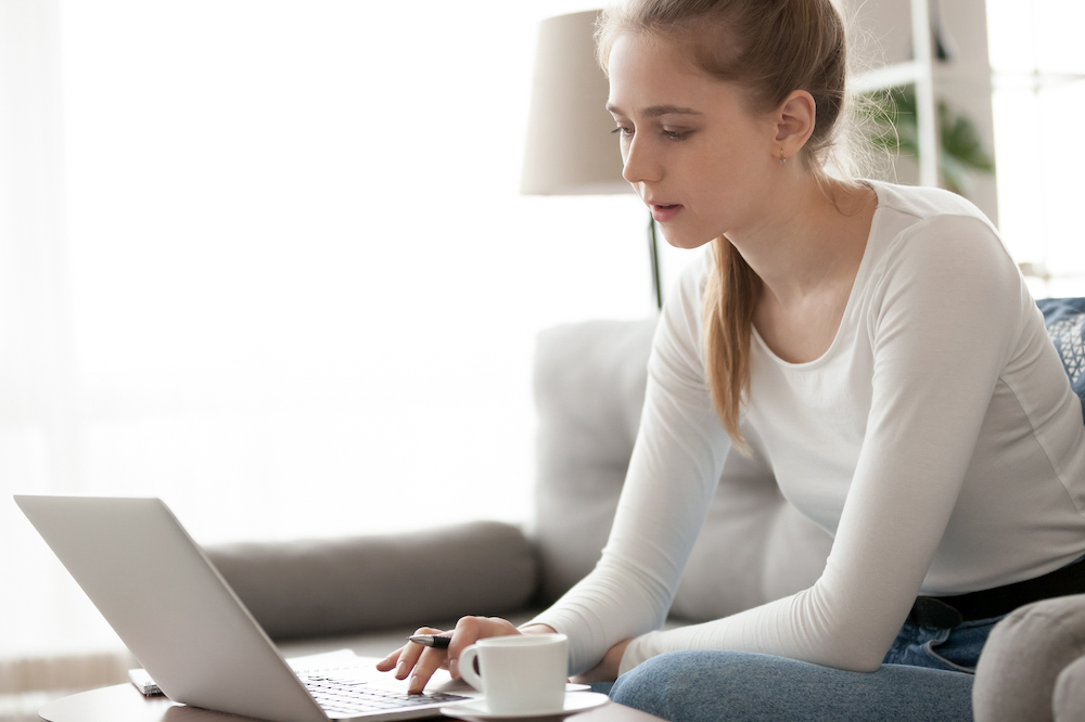 Female student using a laptop on her sofa