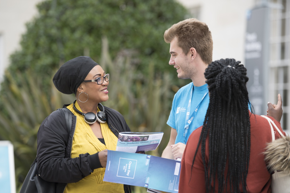 Student helping visitors at an open day