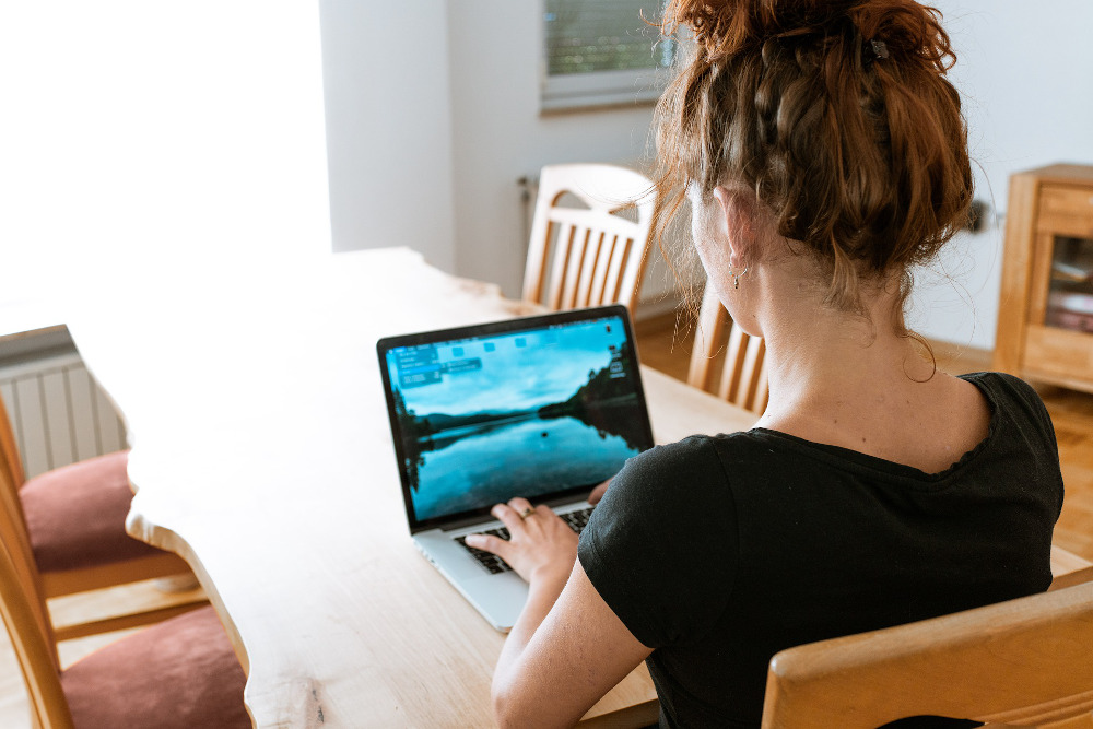 Woman using laptop at her dining room table
