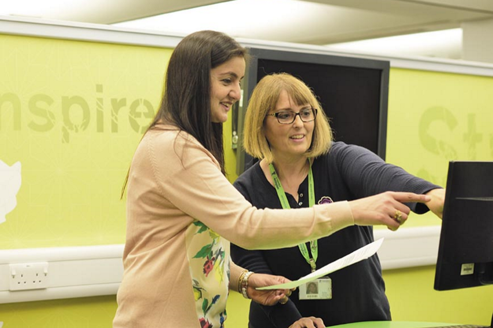 Library staff member helping a student