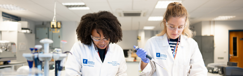 Photograph of two students in a lab